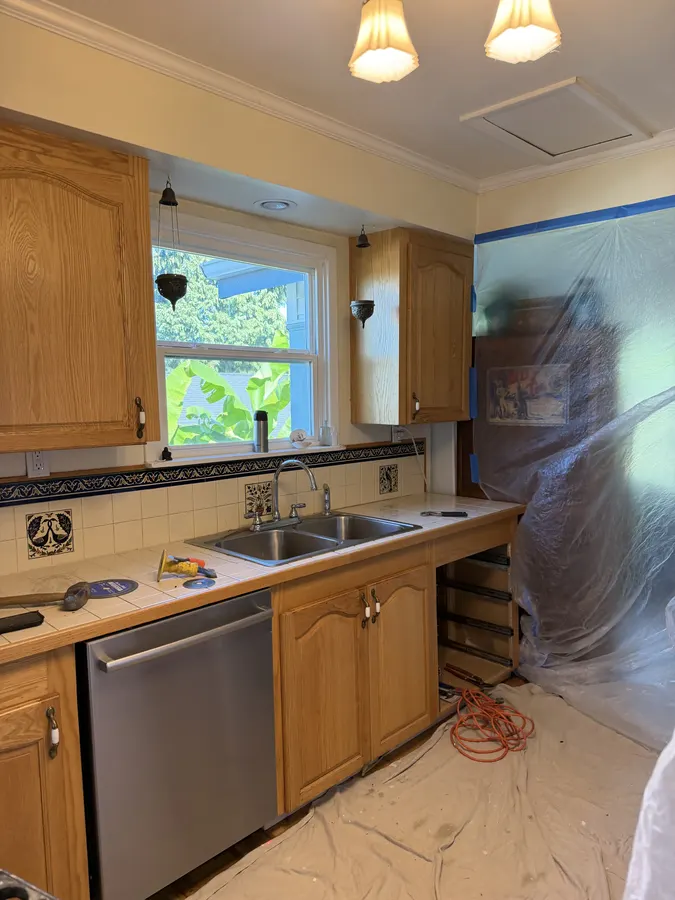 Kitchen protected with floor coverings and plastic sheeting during countertop replacement