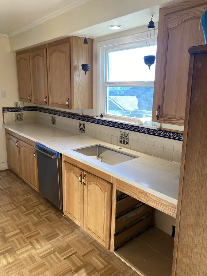 Wide view of the finished quartz countertop and undermount sink beneath the kitchen window